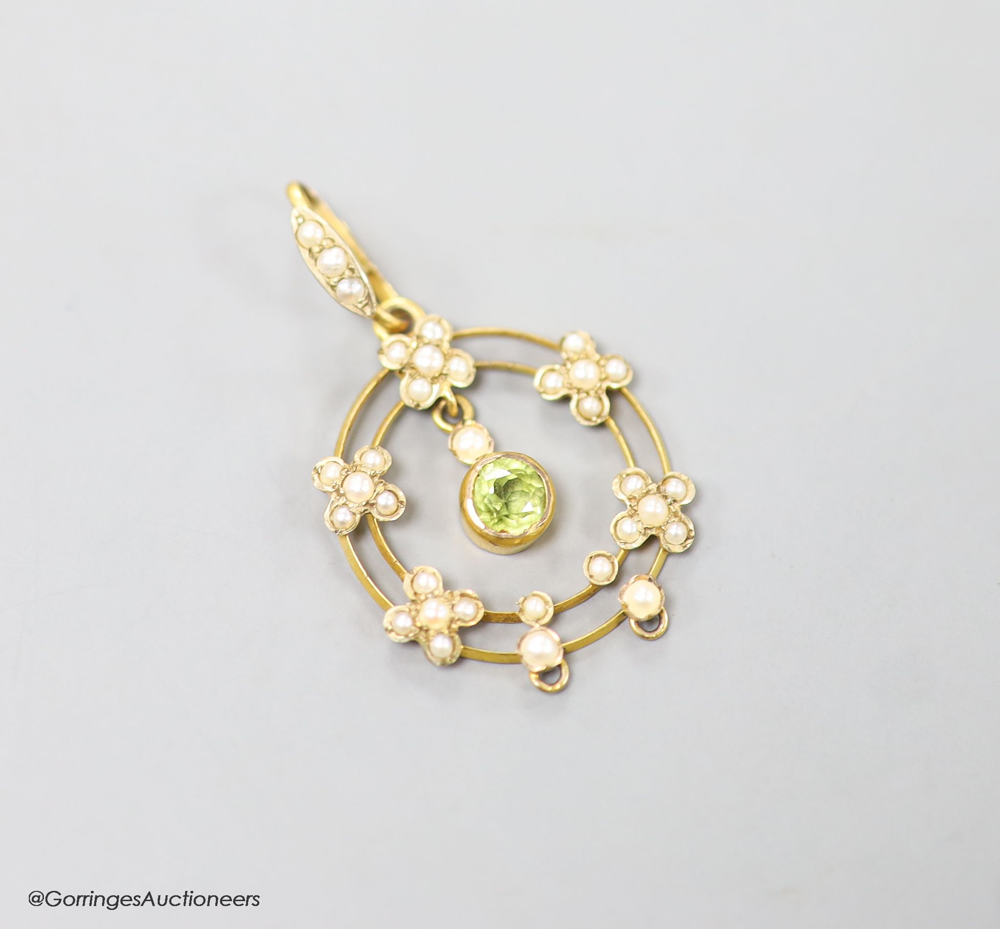 An early 20th century 9ct, peridot and seed pearl set drop pendant, overall 35mm, gross weight 2.1 grams.